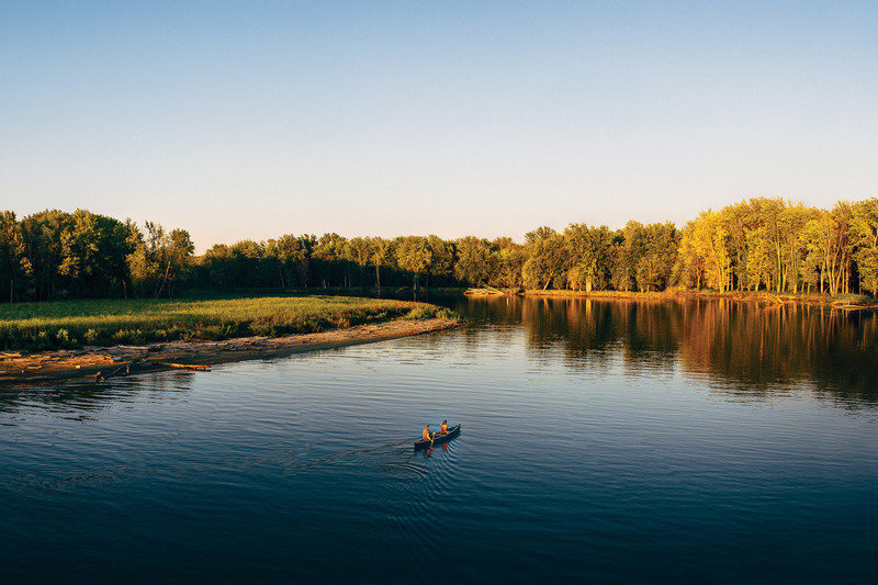 People canoeing down the Winooski River during sunset. Burlington Vermont.